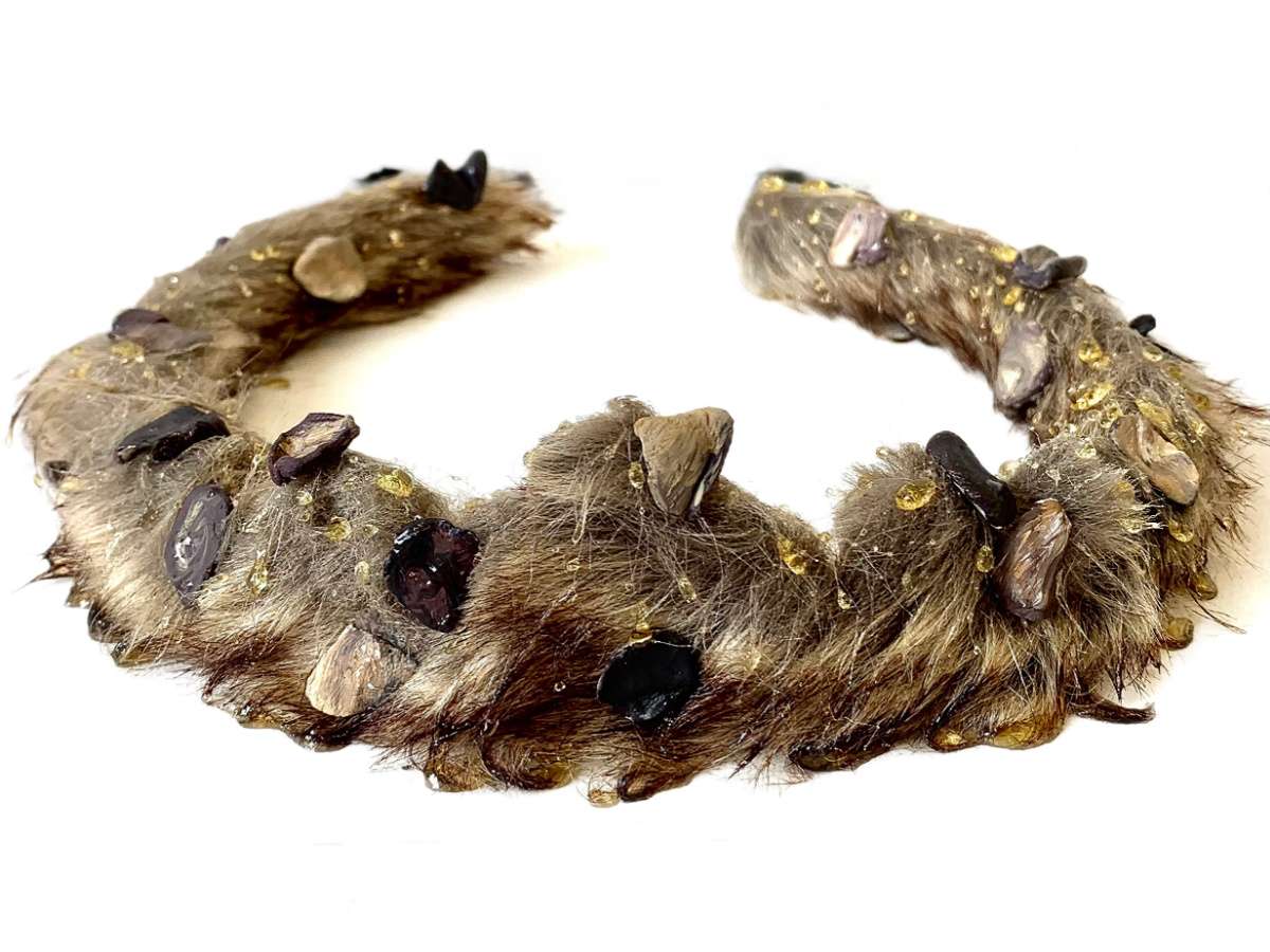A crown made from fur, honey and clay replicas of locust beans.