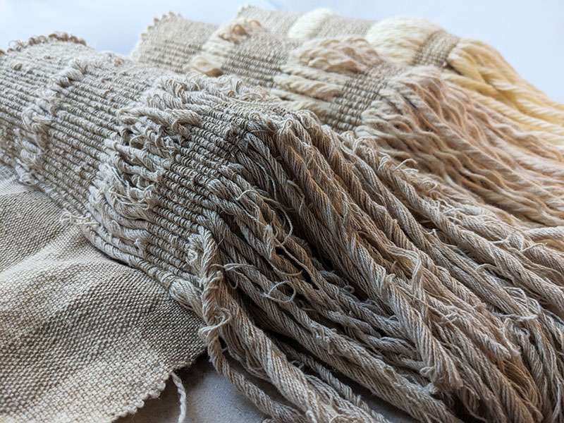 Large pleats, which create 3 large curved bumps, are woven with seacell and linen in the warp, and chunky wool and cotton used as weft, which hangs from one side. Yarn becomes more unruly in each pleat to show gradual disintegration.